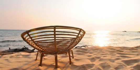 Cambodian sunset with Cambodian-style beach chair in the foreground. By Beachmeter.com.